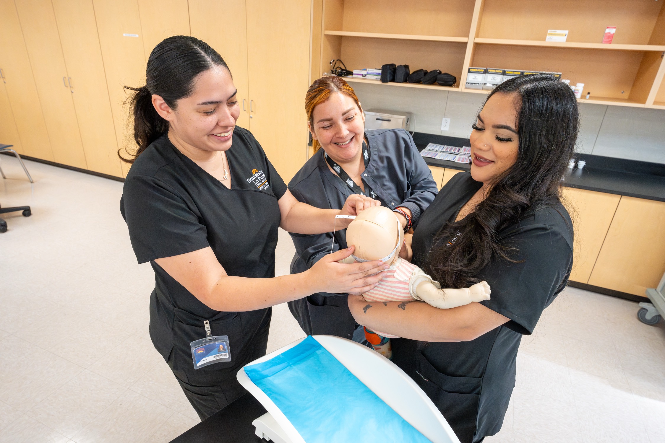 Students measuring baby dolls head